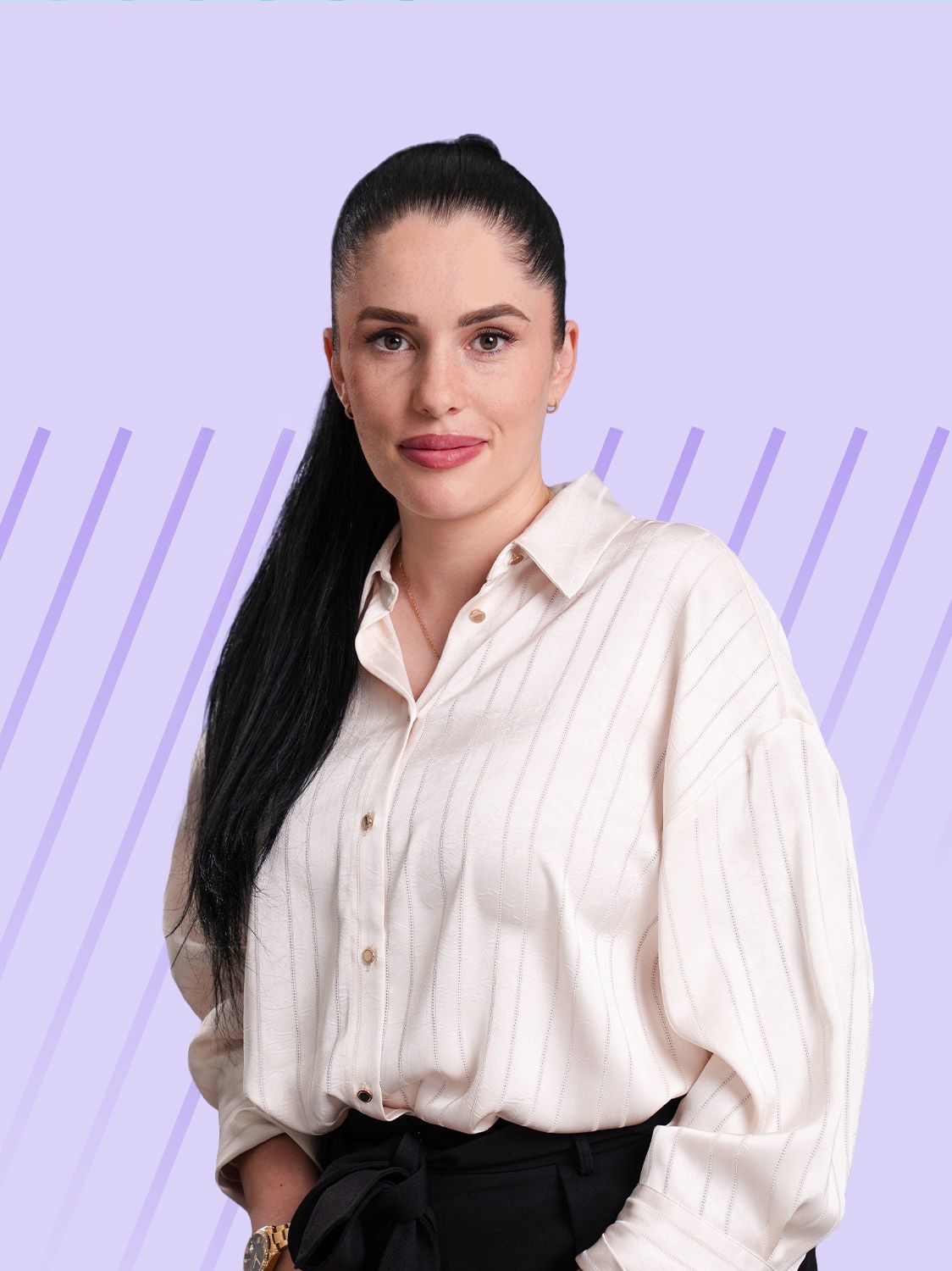 A woman with long dark hair tied in a ponytail, wearing a cream-colored collared shirt.