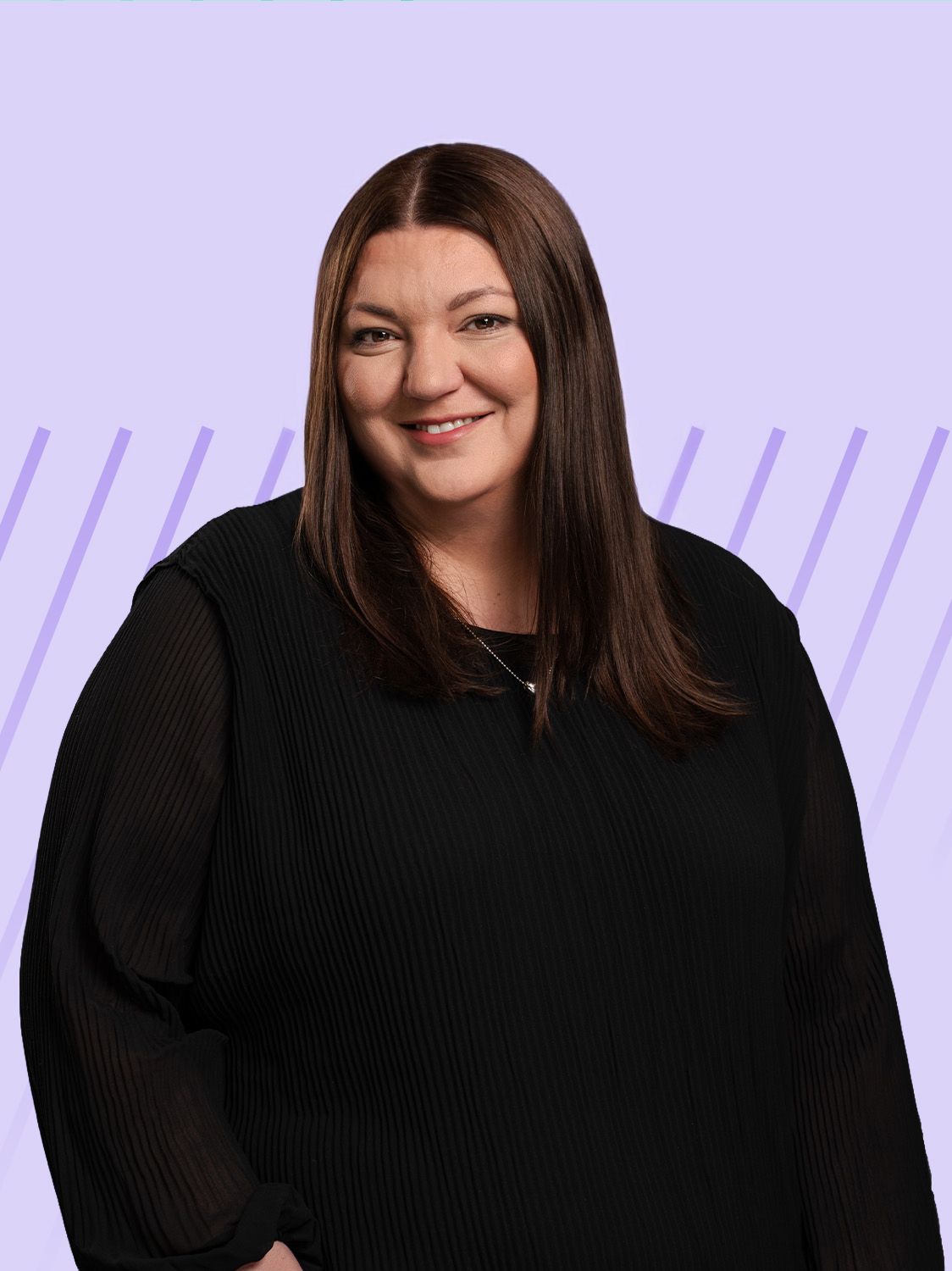 A smiling woman with long dark hair wearing a black top stands against a light purple background.