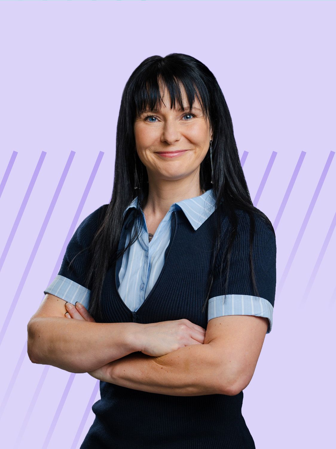 Smiling professional woman with dark hair and bangs, wearing a collared top, arms crossed.