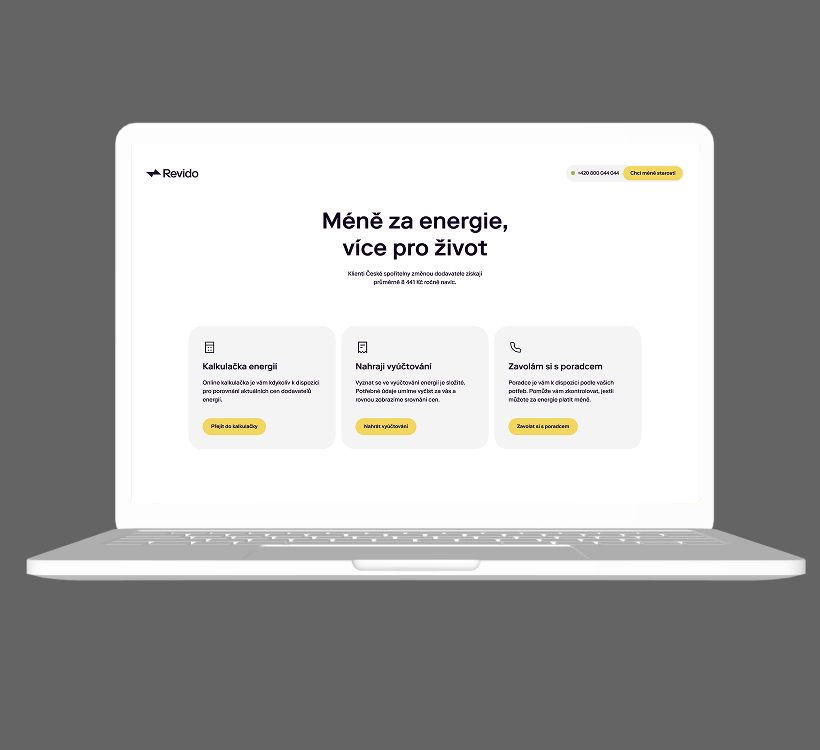 White laptop displays a website with the headline 'Méně za energie, více pro život' and three content boxes.